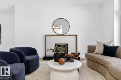 Living area featuring wood finished floors and a fireplace - 218 Omand Drive, Edmonton, AB 