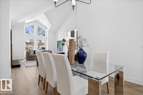 Dining area featuring light wood-style flooring, hanging lights, and vaulted ceiling - 218 Omand Drive, Edmonton, AB 