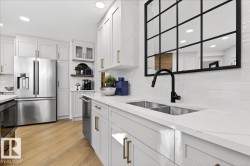 Kitchen featuring stainless steel appliances, recessed lighting, light wood finished floors, white cabinets, and glass insert cabinets - 