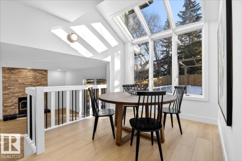 Dining area with a skylight, light wood-type flooring, and vaulted ceiling - 218 Omand Drive, Edmonton, AB 