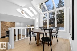 Dining area with a skylight, light wood-type flooring, and vaulted ceiling - 