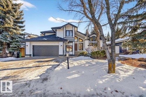 View of front of house with driveway, a garage, and stucco siding - 218 Omand Drive, Edmonton, AB 