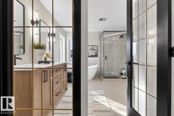 Full bath featuring a shower stall, vanity, a soaking tub, light tile patterned floors, and french doors - 