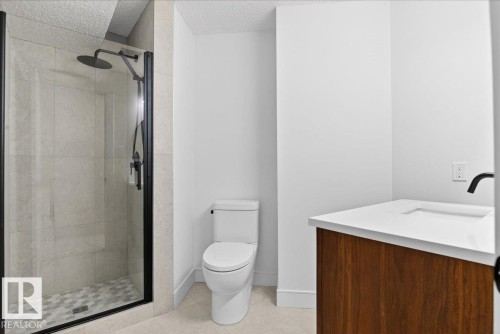Bathroom with vanity, a shower stall, and a textured ceiling - 218 Omand Drive, Edmonton, AB 