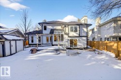 Snow covered house with a chimney and stucco siding - 