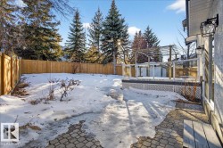 Snowy yard featuring a fenced backyard and a deck - 