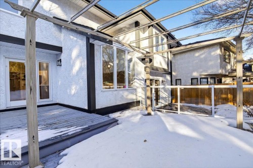 Rear view of house with stucco siding and a deck - 218 Omand Drive, Edmonton, AB 