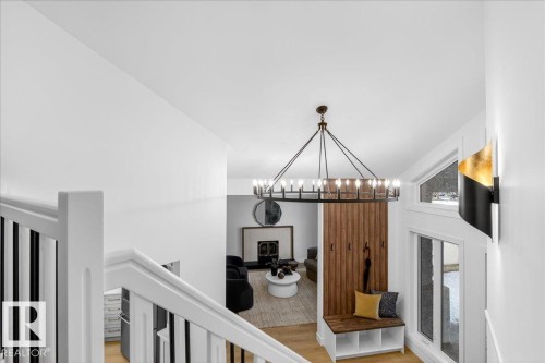 Hall with light wood-style flooring and hanging lights - 218 Omand Drive, Edmonton, AB 