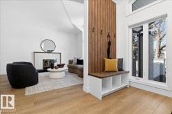 Mudroom featuring a tiled fireplace and light wood finished floors - 