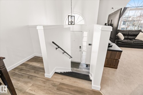 Entrance foyer featuring light wood finished floors and hanging lights - 3015 49, Beaumont, AB - Indoor Photo Showing Other Room
