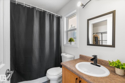 Bathroom with vanity, a shower with shower curtain, and a textured ceiling - 3015 49, Beaumont, AB - Indoor Photo Showing Bathroom