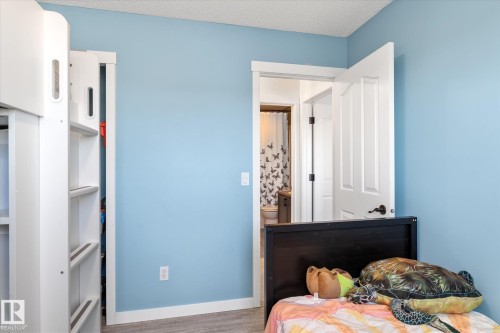 Bedroom featuring a textured ceiling and wood finished floors - 3015 49, Beaumont, AB - Indoor Photo Showing Bedroom