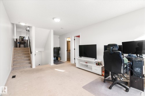 Carpeted home office featuring a textured ceiling and baseboards - 3015 49, Beaumont, AB - Indoor Photo Showing Office