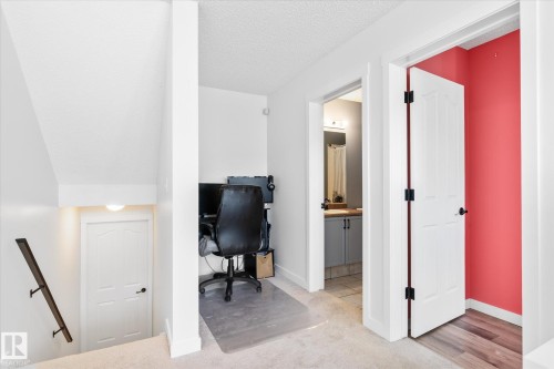 Carpeted office space featuring a textured ceiling and baseboards - 3015 49, Beaumont, AB - Indoor Photo Showing Other Room