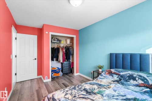 Bedroom featuring dark wood-style floors, a closet, and a textured ceiling - 3015 49, Beaumont, AB - Indoor Photo Showing Bedroom