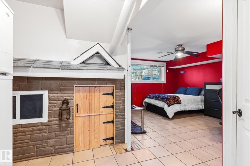 Bedroom featuring light tile patterned floors, a ceiling fan, and freestanding refrigerator - 3015 49, Beaumont, AB - Indoor