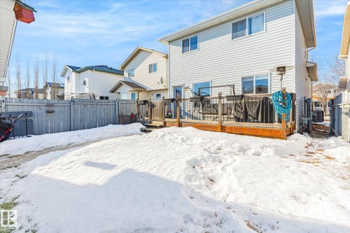 Snow covered rear of property with a fenced backyard and a deck - 3015 49, Beaumont, AB - Outdoor With Deck Patio Veranda