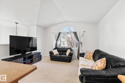 Living room featuring light carpet and baseboards - 3015 49, Beaumont, AB - Indoor Photo Showing Living Room