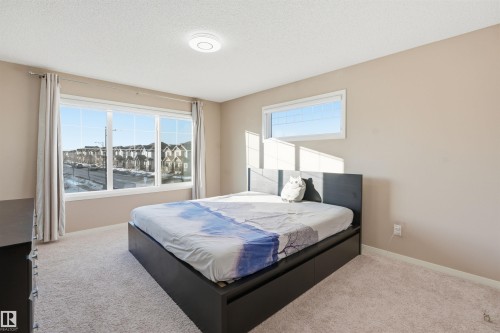 Carpeted bedroom with baseboards and a textured ceiling - 5003 Andison Close, Edmonton, AB - Indoor Photo Showing Bedroom