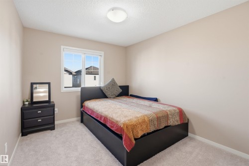 Bedroom with light colored carpet and a textured ceiling - 5003 Andison Close, Edmonton, AB - Indoor Photo Showing Bedroom