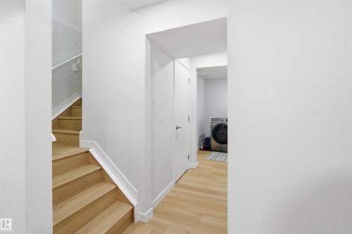 Staircase featuring wood finished floors and washer / dryer - 5003 Andison Close, Edmonton, AB - Indoor Photo Showing Other Room