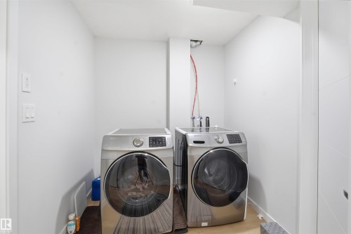 Laundry room featuring washing machine and clothes dryer and wood finished floors - 5003 Andison Close, Edmonton, AB - Indoor Photo Showing Laundry Room