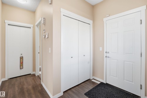 Entryway with dark wood-style floors and a textured ceiling - 5003 Andison Close, Edmonton, AB - Indoor Photo Showing Other Room