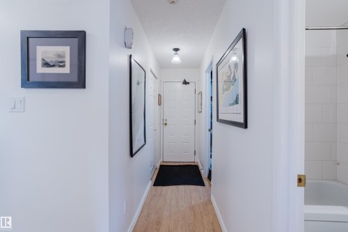 Hall featuring baseboards and light wood-style floors - 115 10545 Saskatchewan Drive, Edmonton, AB - Indoor Photo Showing Other Room