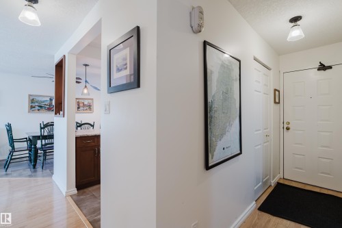 Foyer entrance with light wood finished floors and a textured ceiling - 115 10545 Saskatchewan Drive, Edmonton, AB - Indoor Photo Showing Other Room