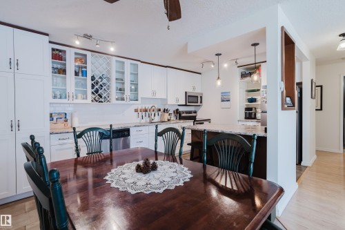 Dining space featuring ceiling fan, light wood finished floors, rail lighting, and a textured ceiling - 115 10545 Saskatchewan Drive, Edmonton, AB - Indoor Photo Showing Dining Room