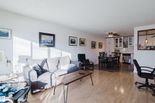 Living room with light wood-type flooring and a ceiling fan - 115 10545 Saskatchewan Drive, Edmonton, AB - Indoor