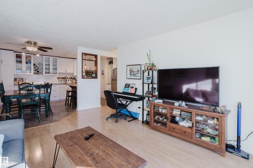 Living area featuring light wood-style floors and a ceiling fan - 115 10545 Saskatchewan Drive, Edmonton, AB - Indoor Photo Showing Living Room