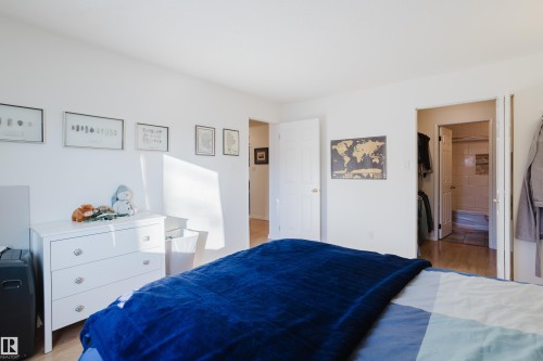 Bedroom featuring wood finished floors and ensuite bathroom - 115 10545 Saskatchewan Drive, Edmonton, AB - Indoor Photo Showing Bedroom