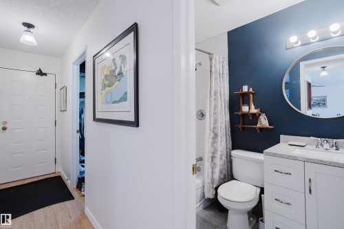 Full bathroom with vanity, shower / bath combination with curtain, and light wood finished floors - 115 10545 Saskatchewan Drive, Edmonton, AB - Indoor Photo Showing Bathroom