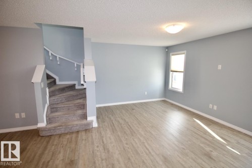 Unfurnished living room with a textured ceiling and wood finished floors - Upper 516 Ebbers Way, Edmonton, AB - Indoor Photo Showing Other Room