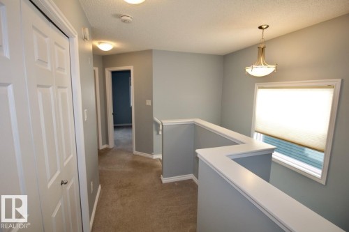 Hall with an upstairs landing, a textured ceiling, and dark colored carpet - Upper 516 Ebbers Way, Edmonton, AB - Indoor Photo Showing Other Room