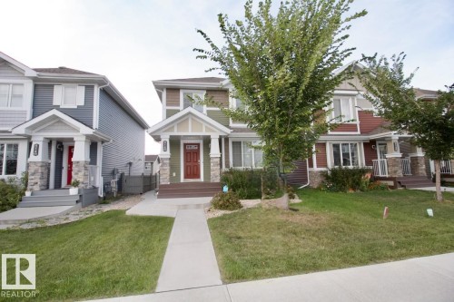 View of front of property with a front yard and stone siding - Upper 516 Ebbers Way, Edmonton, AB - Outdoor With Facade