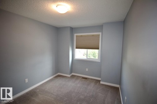 Carpeted spare room with a textured ceiling and baseboards - Upper 516 Ebbers Way, Edmonton, AB - Indoor Photo Showing Other Room