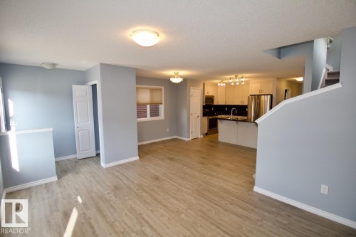 Unfurnished living room with light wood-style flooring and a textured ceiling - Upper 516 Ebbers Way, Edmonton, AB - Indoor Photo Showing Kitchen