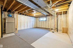 Below grade area featuring freestanding refrigerator - 