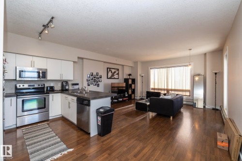 Kitchen with a peninsula, stainless steel appliances, open floor plan, and white cabinets - 2005 10136 104 Street, Edmonton, AB - Indoor Photo Showing Kitchen With Stainless Steel Kitchen