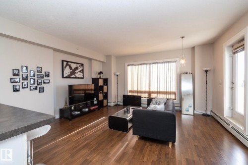 Living room with a baseboard radiator and dark wood-style flooring - 2005 10136 104 Street, Edmonton, AB - Indoor Photo Showing Living Room