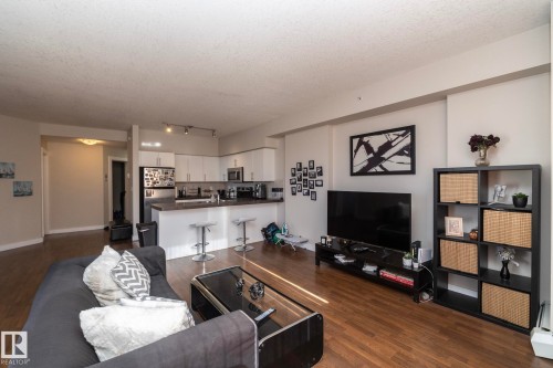 Living room featuring dark wood-type flooring and a textured ceiling - 2005 10136 104 Street, Edmonton, AB - Indoor Photo Showing Living Room