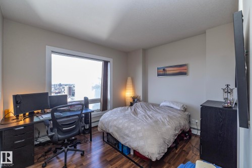 Bedroom featuring wood finished floors, a desk, and a baseboard radiator - 2005 10136 104 Street, Edmonton, AB - Indoor Photo Showing Bedroom
