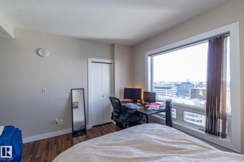 Bedroom featuring a desk, dark wood-type flooring, and a closet - 2005 10136 104 Street, Edmonton, AB - Indoor Photo Showing Bedroom