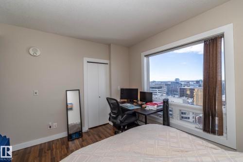Bedroom with a desk, dark wood-type flooring, and a closet - 2005 10136 104 Street, Edmonton, AB - Indoor Photo Showing Bedroom