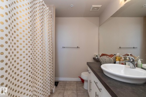 Full bathroom with a shower with curtain, vanity, and light tile patterned floors - 2005 10136 104 Street, Edmonton, AB - Indoor Photo Showing Bathroom