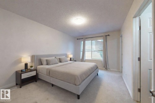 Bedroom with a textured ceiling and light carpet - 1030 177A Street, Edmonton, AB - Indoor Photo Showing Bedroom