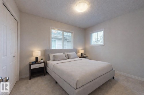 Bedroom with a textured ceiling, a closet, and light colored carpet - 1030 177A Street, Edmonton, AB - Indoor Photo Showing Bedroom