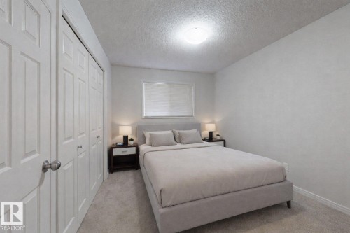 Bedroom featuring carpet floors, a textured ceiling, and a closet - 1030 177A Street, Edmonton, AB - Indoor Photo Showing Bedroom